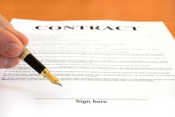 Hand pointing at signature place on a contract document