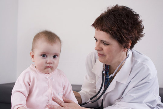 Pediatrician using a stethoscope at a well-baby check.