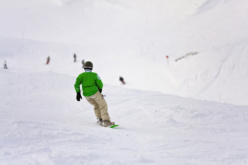 Fototapeta na wymiar Młody snowboardzistka w dół stoku narciarskim