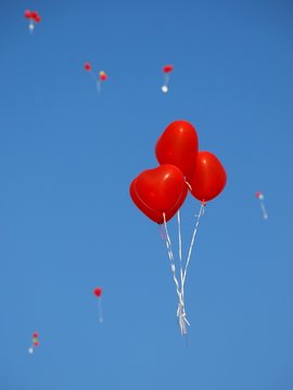 Rote herzförmige Luftballons mit blauem Himmel