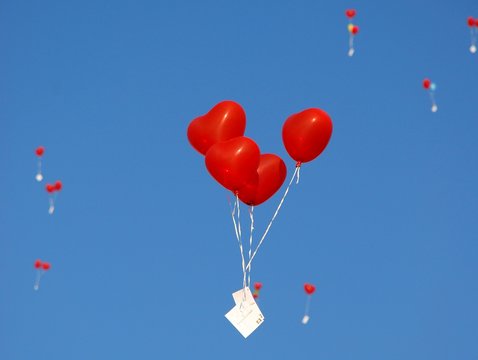 Rote herzförmige Luftballons mit blauem Himmel