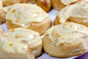 A plate full of fresh sweet rolls ready to be eaten.