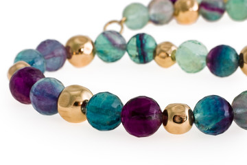 Beads from multi-coloured stones and gold on a white background