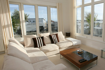 Interior of modern living room with beige corner suite
