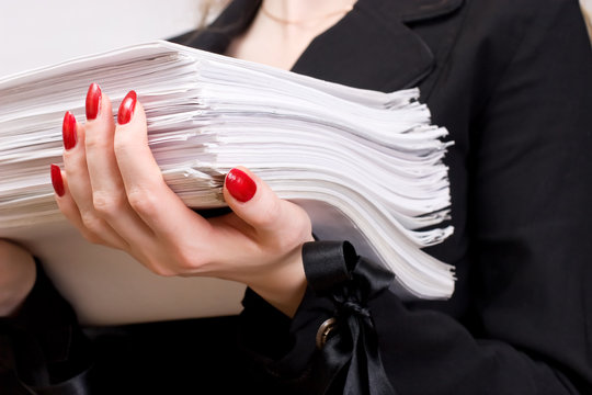 Businesswoman with heap of papers closeup.