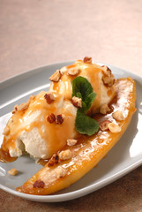 Banana with vanilla ice cream, caramel sauce and hazelnuts