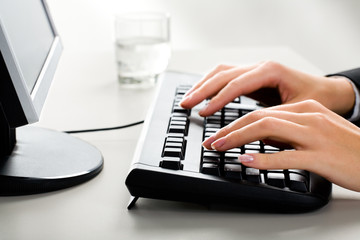 Photo of female hands on the keyboard of computer 
