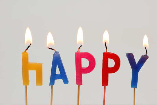 Burning candles with the word "Happy"