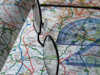 Glasses and protractors on an open map.