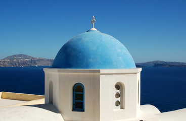 Fototapeta na wymiar A colorful blue dome in the Santorini cliff town of Oia.