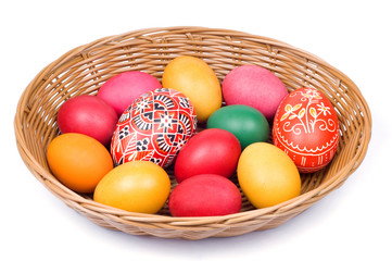 Fototapeta na wymiar Colorful Easter eggs in straw basket on white background