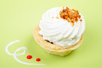 Delicious cream cake with soft shadow on green dish. Shallow DOF