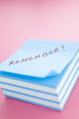 Pile of sticky notes with  text over a pink table