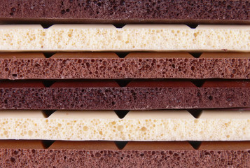 A background of all sorts of chocolate: white, milk and black