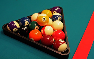 Close-up shot of pool table and balls in triangle.