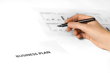 paper on desk with business plan on it. 