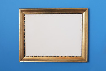 Fototapeta premium Old golden photo frame on blue