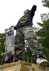 Teenager in Camouflage with Skateboard at Park