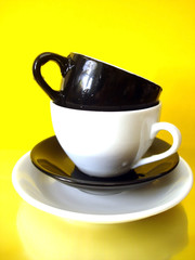 white and black cups on yellow background