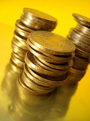 Stack of golden coins on yellow background