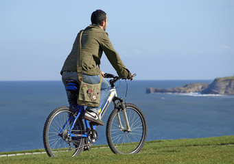 Joven en bicicleta por la costa