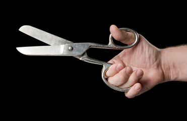 Scissors in a hand on a black background.