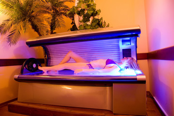 beautiful woman resting in tanning bed at the spa