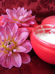Obraz na płótnie Canvas cosmetic moisturizing cream and towel with flowers