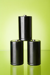 Obraz premium Three batteries on green background