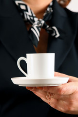 A woman holds a cup filled with black coffee or tea