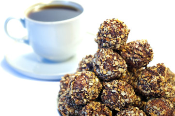 chocolate sweets whith nuts and white cup of coffee
