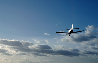 Fototapeta na wymiar lekki samolot na podejściu do lądowania przy zachodzie słońca