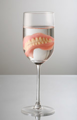 artificial Teeth on wine glass, with water