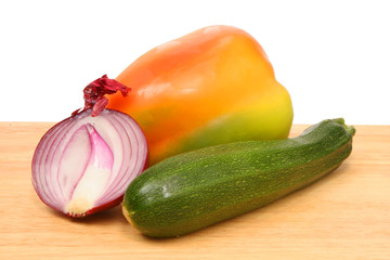 onion,corgette and pepper on wooden board