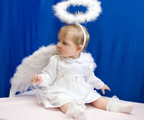 Girl angel in white clothes and with wings on a blue background