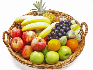 Korb gefüllt mit frischen grünen und roten Äpfeln, Bananen, dunklen Trauben, Orangen, Feigen, Sternfrüchten und Babyananas freigestellt auf weißem Hintergrund