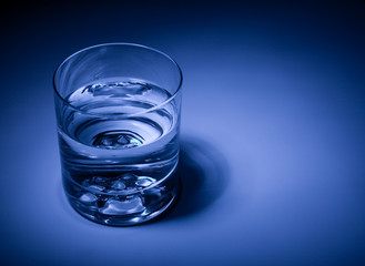 Glass of mineral water close-up. Blue tone. Shallow DOF..