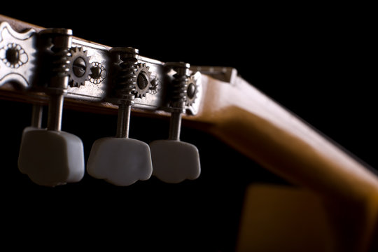 Close-up of acoustic guitar on black background. Shallow DOF..