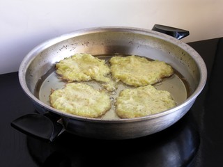 raw potato pancakes frying on hot oil 