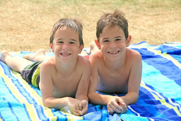 Fototapeta premium Boys Laying on Beach Towels