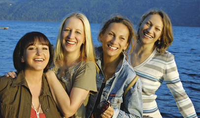 Four girls having fun beside a lake.