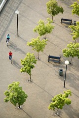 overhead view of a couple cycling through a plaza © greenstockcreative