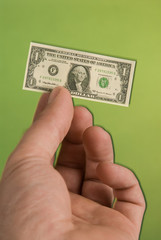 a hand holding a miniature United States one dollar bill 