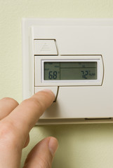 turning down a home thermostat to save energy