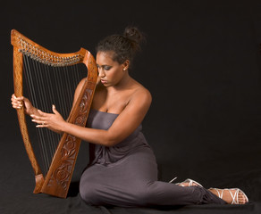 portrait of young beautiful woman with harp