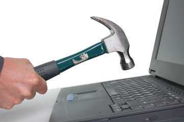 Taking a hammer to a dead laptop in frustration.