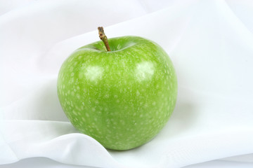 Green, healthy, organic apple on a textile background