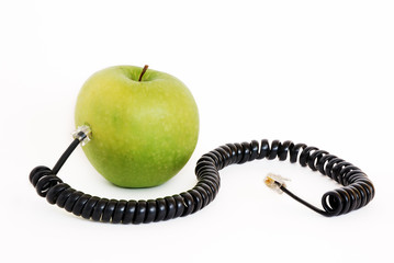 Green apple plugged with wire isolated on white