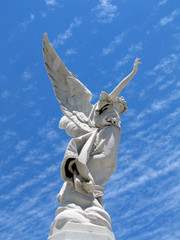 Detail of winged angel statue against blue sky