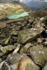 Blue mountain lake with stones in foreground.